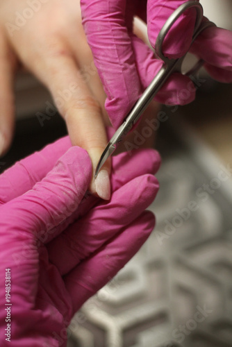 Nail shaping and cuticle trimming with cuticle scissors during professional manicure