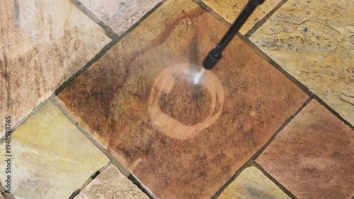 Using a pressure washer to paint a sun on a patio tile