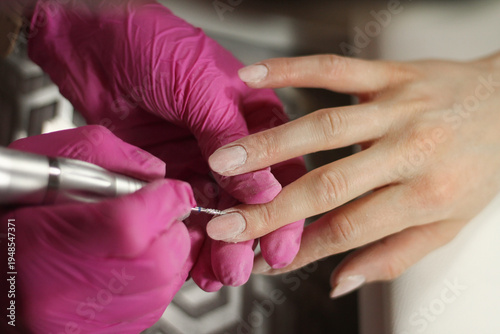 Cuticle and nail preparation with electric nail drill during professional manicure