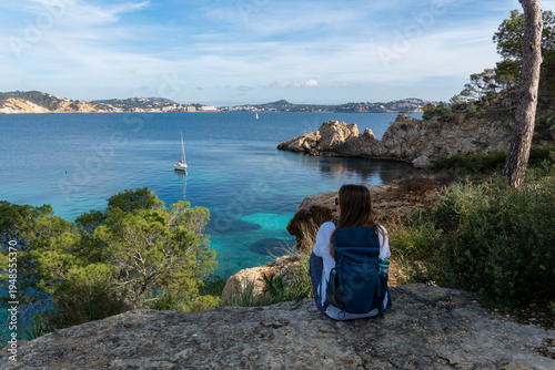Woman with Backpack Enjoying the Scenic View over Cala Fornells Bay in Mallorca