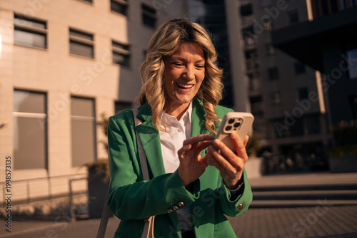 Professional woman smiling using smartphone in city