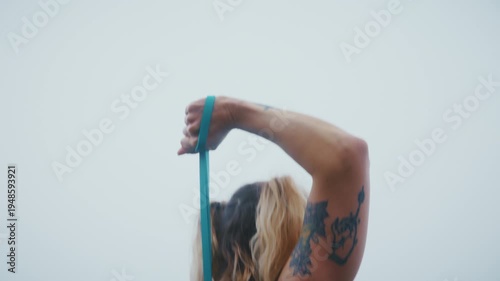 Tattooed Fit Woman Preparing Resistance Band Outdoor Foggy Day