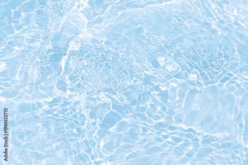 Blue water with ripples on the surface. Defocus blurred transparent blue colored clear calm water surface texture with splashes and bubbles. Water waves with shining pattern texture background.