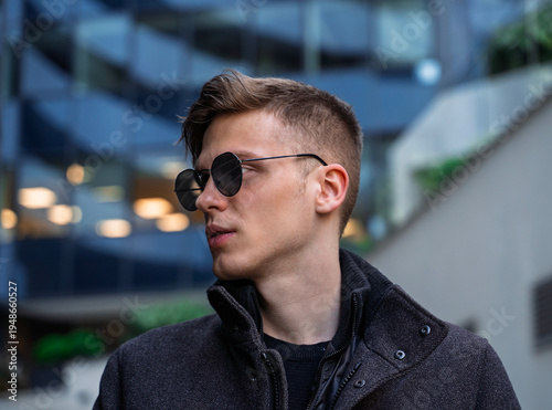 Photos Fashion side view portrait of handsome blonde young guy with sunglasses