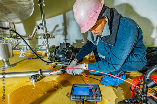 A man starts using a weld pipe stainless inspection camera. The light monitor shows images from the camera head