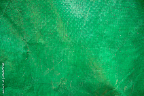 Canvastavla Green plastic tarpaulin with a coarse woven texture and a wrinkled surface