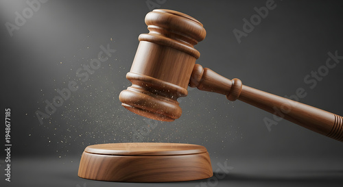 Wooden gavel hitting a sound block with dust particles flying around it