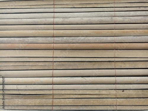 Close-up view of a bamboo blind with horizontal slats and red string