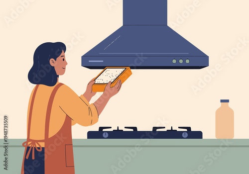 A woman cleans a grease filter in her kitchen, demonstrating maintenance. Bright, clean, and practical. Focus on the filter and her hands.