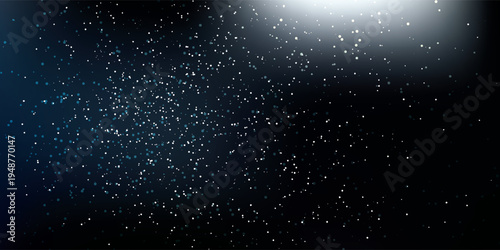 Abstract particles floating in dark space with light effect.