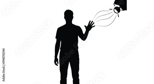 Silhouette of a man interacting with a projected digital light source or sensor using his outstretched hand against white background