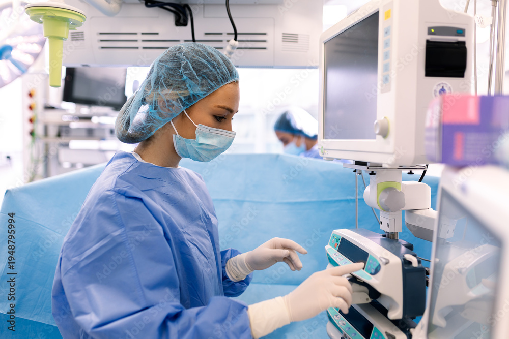 Naklejka premium Female surgeon monitoring medical vitals on screen in operating room. Healthcare and medicine concept, surgical professional using advanced hospital technology, and anesthesia monitor monitoring.