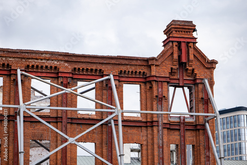 Fotografie Facade reconstruction showing old brick building preserved with steel support st