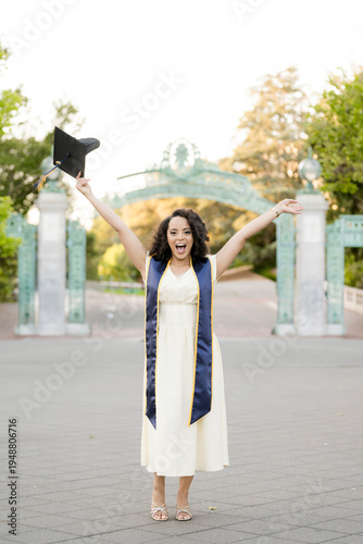 Foto Excited Berkeley graduate celebrating with cap at iconic campus gate