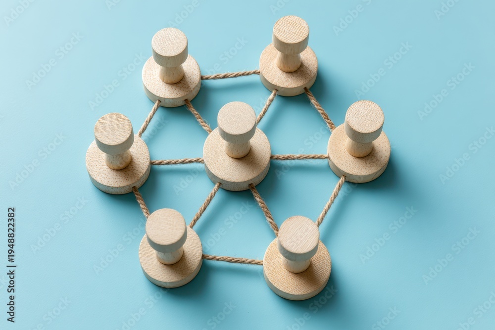 Obraz premium Connected Pins: Wooden pins interlinked, representing teamwork and unity, with a touch of simplicity.