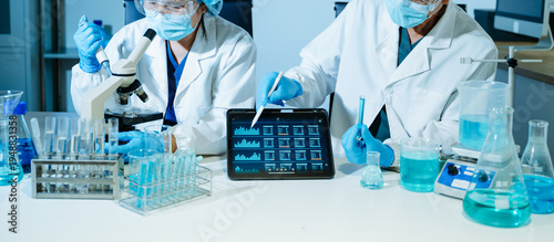 Medical scientists performing biotechnology laboratory research with DNA molecular analysis, microscope testing and digital healthcare technology