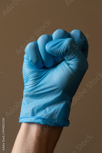 Hand wearing blue medical glove showing various gestures and signs against neutral background. Concept of hygiene, protection and communication with hand signals.
