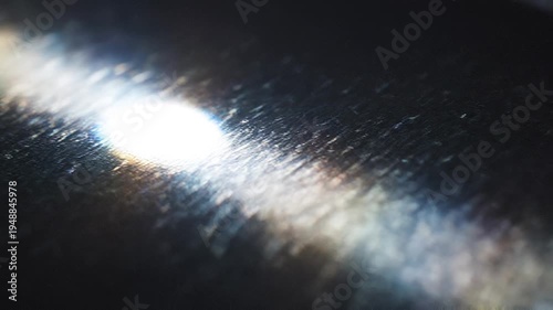 A bright light shines on a dark surface with streaks of light.