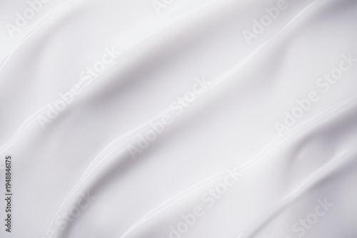 Smooth white cream texture forming elegant flowing waves and swirls