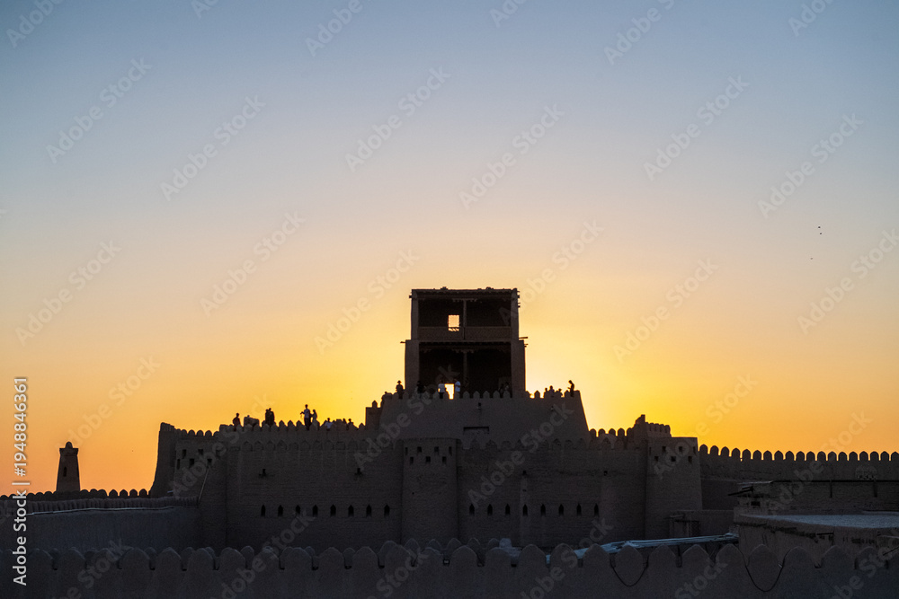 Fototapeta premium Backlit image of the famous Kuhna Ark, a fortified citadel in the city center of historic Khiva.