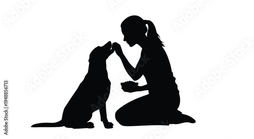 Woman kneeling gently touching noses with her dog a striking silhouette
