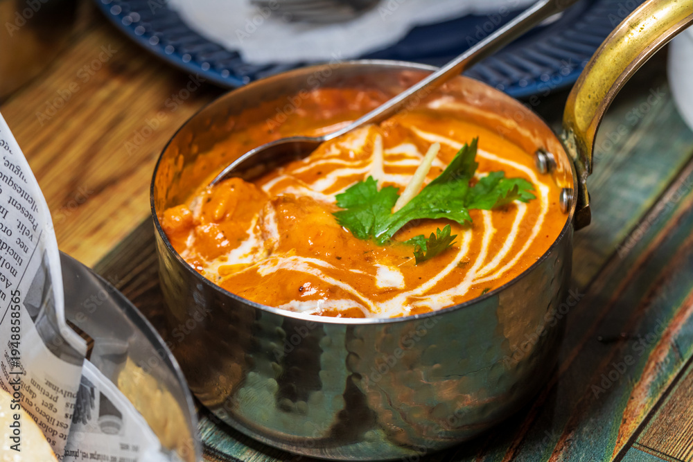 Fototapeta premium Various rich Indian curries served in traditional copper pots