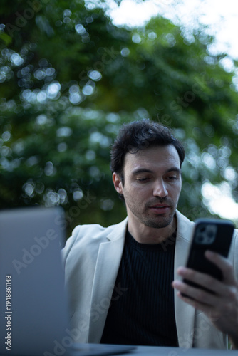 Fotografía Entrepreneur reading message on smartphone in outdoor workspace