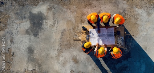 The Construction Team Reviewing Blueprints on a Concrete Site From Aerial View
