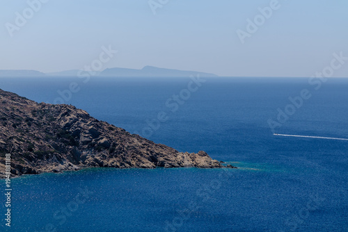 View of huge rocks next to the sea and the island of Santorini in the background 