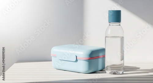 A blue lunch box and a clear spray bottle on a table