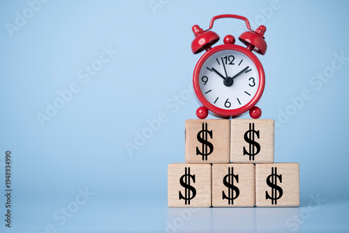 Alarm clock placed on stacked dollar symbol blocks represent time is money, financial growth, investment strategy, business profit planning, wealth building and economic success concept.