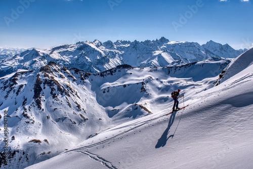 Snowy Mountain Skiing. Skier Carving Fresh Snow Against Majestic Mountain Backdrop. Remote Mountain Landscape Illustrating Solitude Alongside Thrills Of Winter Sports. Ski tour to the Hochfinsler moun