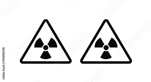 Two identical black triangular warning signs displaying a radioactive symbol