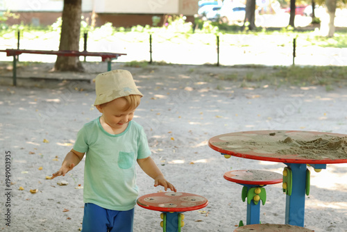 Fotografie A distracted, curious child stands on the playground