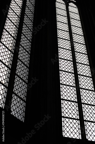 Black and white image of a window with an ornamental lattice pattern in an old church