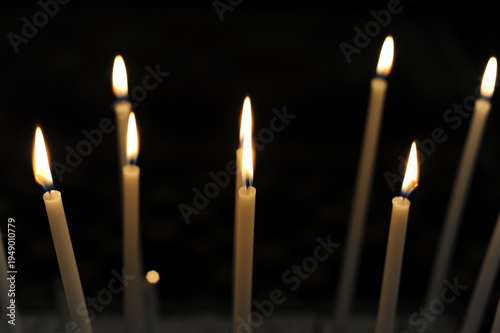 Burning candles in the dark chamber room of a church