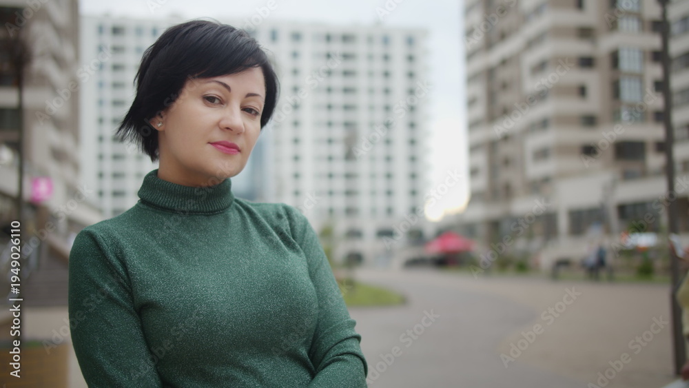 Fototapeta premium portrait of a brunette woman standing on the street and looking at the camera, have fun and enjoy