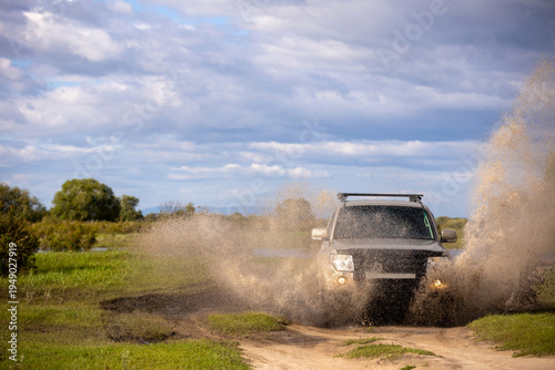 Quadro su tela Japanese SUXV moving by a puddle making a lot of water splashes