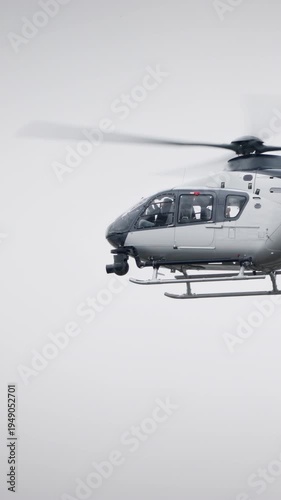 Side view of a helicopter propelled in the sky. Film camera attached at the front to record a movie or perform surveillance of enemy army