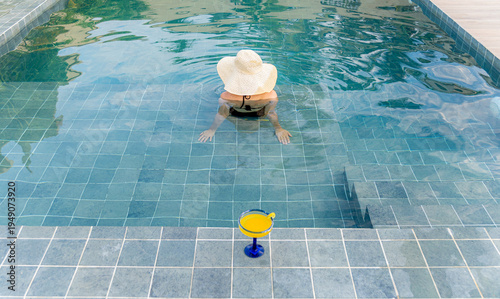 Woman relaxing in a swimming pool on a summer day