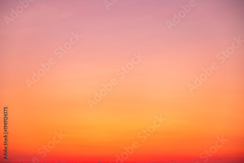 Beautiful sunset sky with golden sun rays and clouds. Dramatic orange and blue morning heaven background. Natural sunrise light effect in summer