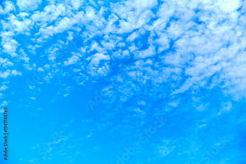 Blue sky background with small cloud texture at the top.
