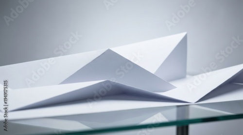 Clean and Simple White Paper Shapes with Elegant Reflection on Glass Surface in Soft Light