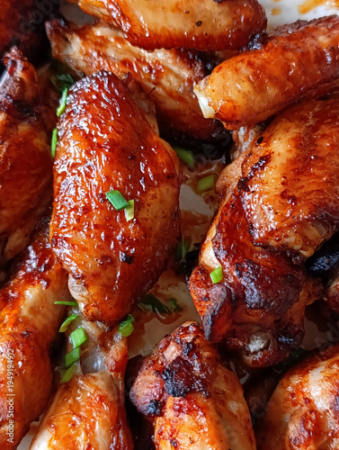 Fotografie Close-up of grilled chicken wings sprinkled with green onions