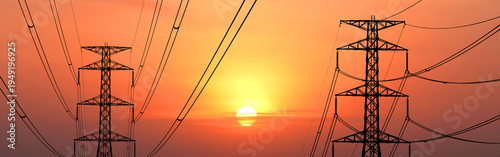Electrical towers silhouetted against a radiant sunset sky