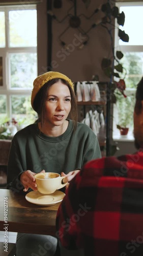 Barista serves coffee and shares ideas with customer at local cafe during afternoon meet