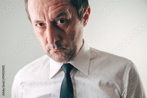 Fotografia Suspicious businessman looking with distrustful expression