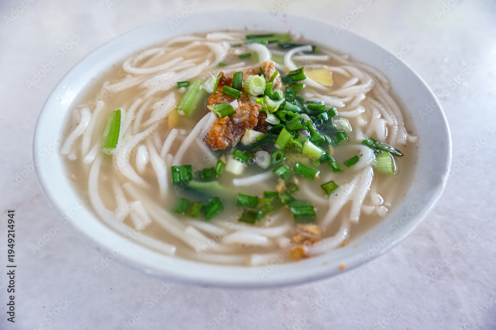 Ταπετσαρία A steaming bowl of comforting, clear broth Bee Hoon Soup (rice vermicelli) captured at a local food stall in George Town, Penang