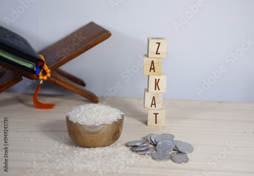 Bild auf Leinwand The background concept of Zakat: Rice on a wooden bowl, prayer beads, a remembrance, and scattered coins