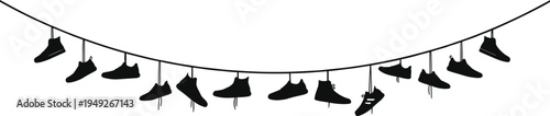 Black silhouette of various sneakers and athletic shoes hanging by laces from a curved power line wire against a white background for urban concept